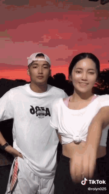 a man and a woman are standing next to each other with a red sky in the background and tiktok written on the bottom