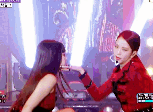 two women on a stage with a sign that says ' i love you '