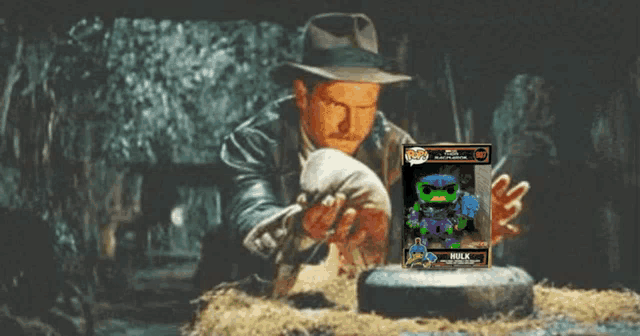a man in a hat is holding a funko pop hulk figure