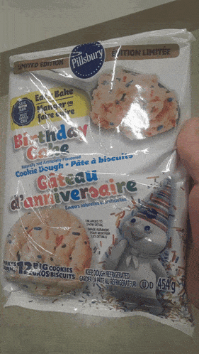 a package of pillsbury birthday cake cookie dough is being held by someone