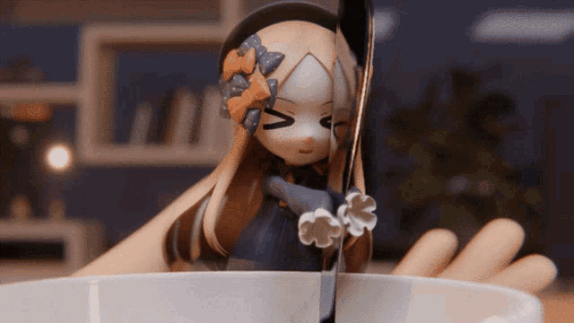 a figurine of a girl with a flower on her head is holding a spoon