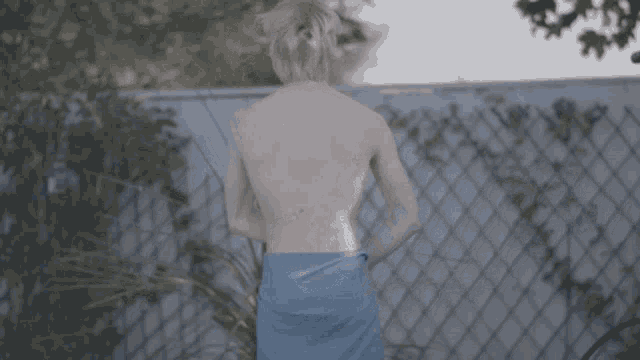 a naked man is wrapped in a blue towel