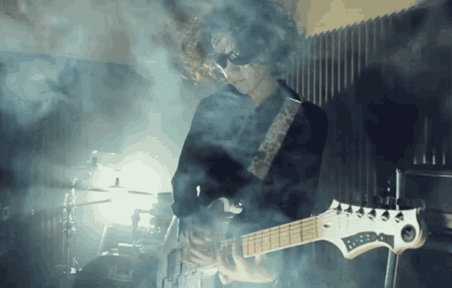 a person playing a guitar in a dark room