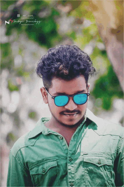 a man wearing sunglasses and a green shirt has a photo taken by mr. duke photography