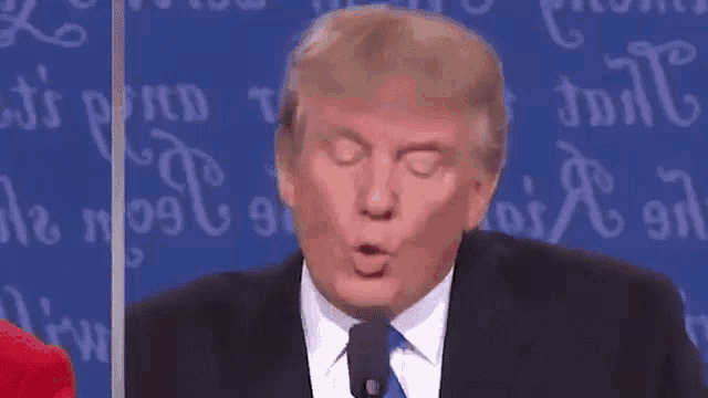 a close up of donald trump 's face while speaking into a microphone .