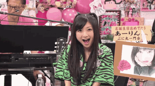 a girl in a green and black zebra print shirt stands in front of a piano keyboard