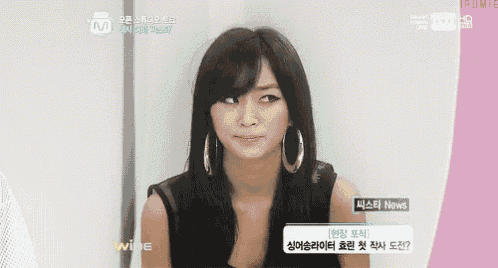 a woman wearing hoop earrings and a black tank top is on a tv screen that says mnet