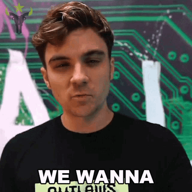 a man wearing a black shirt that says we wanna outlaws on it