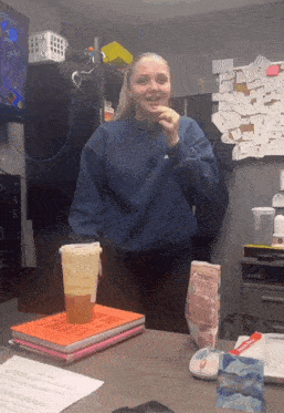 a woman in a blue sweater is eating a snack