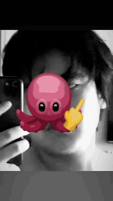 a person is taking a selfie with a red octopus in front of their face