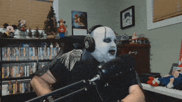 a man wearing headphones and a mask holds a sword