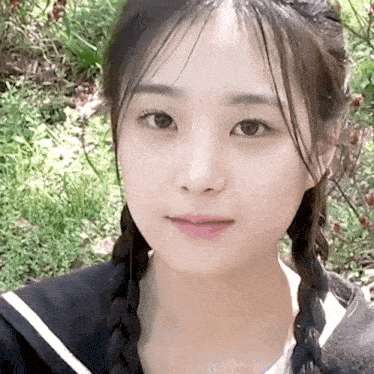 a close up of a woman 's face with braids in her hair .