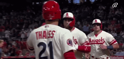 a group of baseball players are standing next to each other on a baseball field .