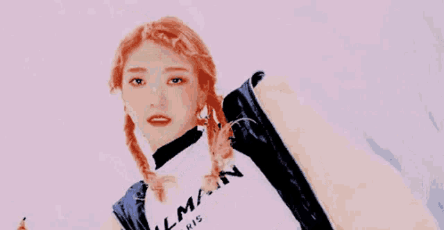 a woman with red hair is wearing a white crop top and a yellow jacket .
