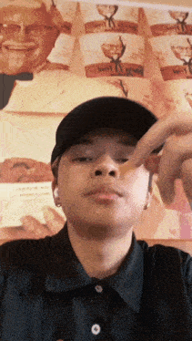 a man wearing a black hat is eating a kfc french fries