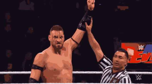 a man in a wrestling ring with a w on the bottom right