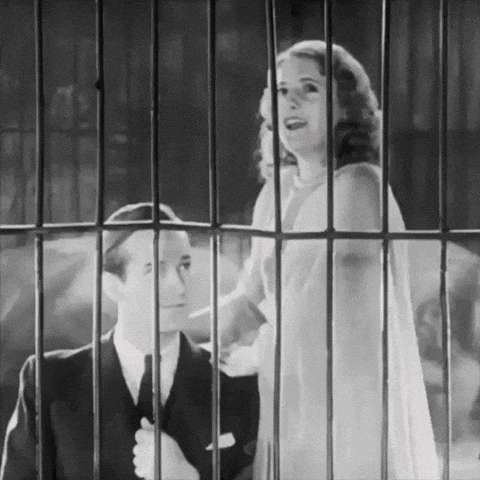 a man and a woman are standing in a cage