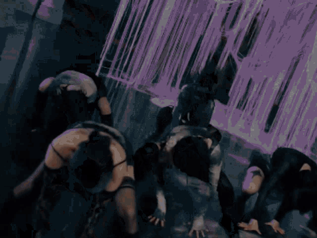 a group of people are dancing in a dark room with a purple background