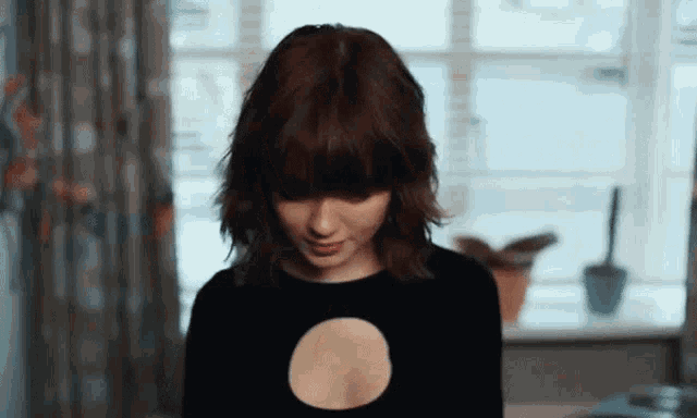 a woman wearing a black top with a hole in the middle of her chest