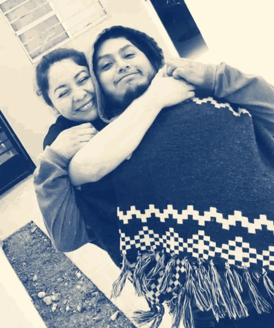 a black and white photo of a man and a woman hugging each other