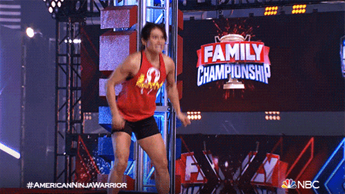 a man in a red tank top is dancing in front of a large screen that says family championship
