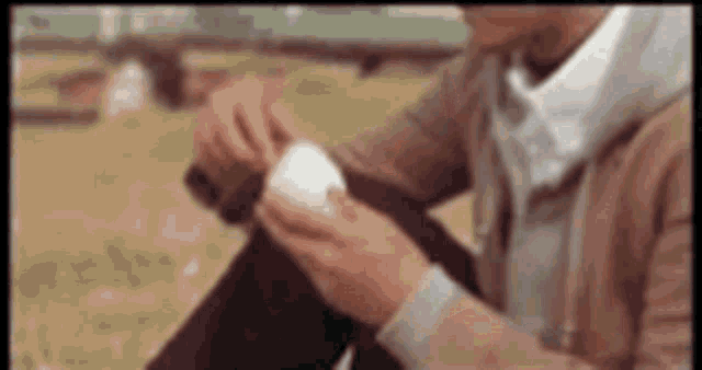 a man is sitting on the ground holding a white ball in his hands .
