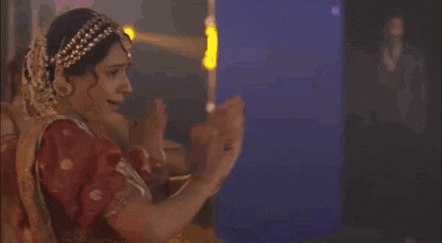 a woman in a white dress is dancing in front of a group of women .