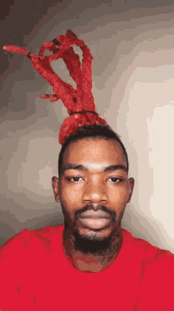 a man with red dreadlocks and a red shirt is taking a selfie