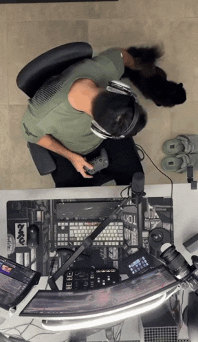 a man sitting at a desk with headphones on and a keyboard that says tokyo