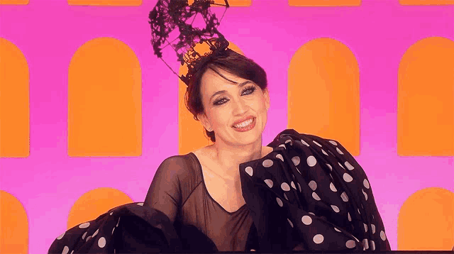 a woman wearing a black and white polka dot dress and a black crown