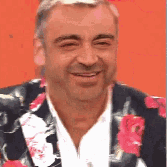 a man wearing a suit with pink roses on it