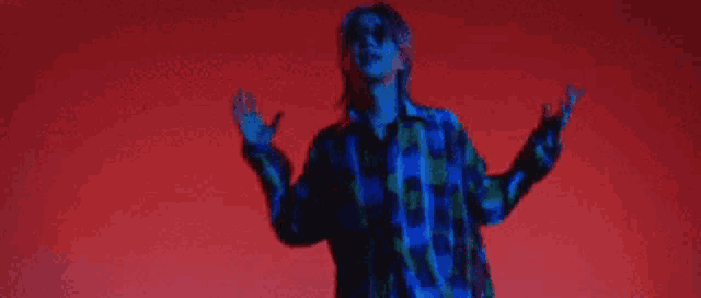 a person is standing in front of a red background with the words new song