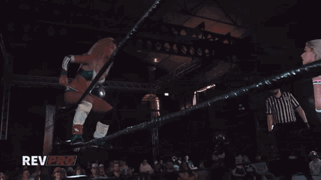 a woman is being lifted in the air by another woman in a rev pro wrestling match