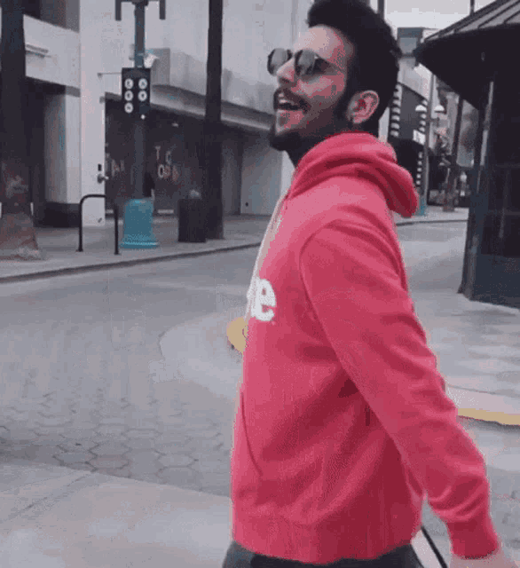 a man wearing sunglasses and a red supreme hoodie