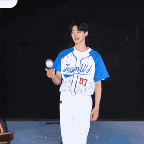 a man wearing a blue and white jersey with the number 07 on it is holding a baseball ..