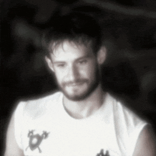 a man with a beard is wearing a white shirt with a fox on the front