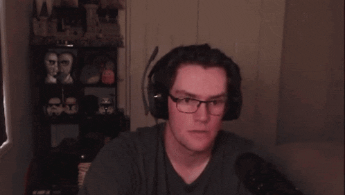 a man wearing glasses and headphones is making a fist in the air