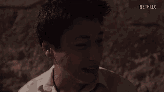 a man is laughing with blood coming out of his mouth in a dark room .