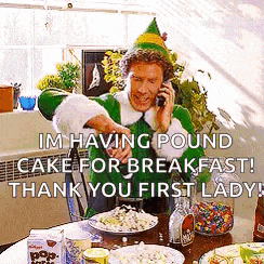 a man in a elf costume is talking on a cell phone while sitting at a table with food .