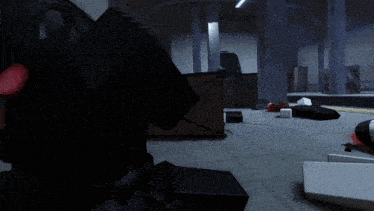 a very dark room with a few boxes on the floor and a speaker that says ' x ' on it