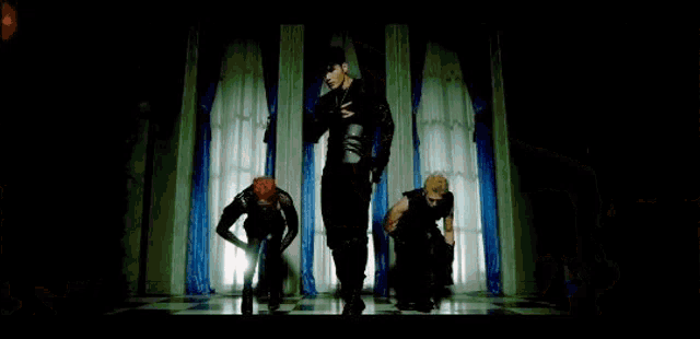 a man in a black and gold outfit is dancing in front of gears .