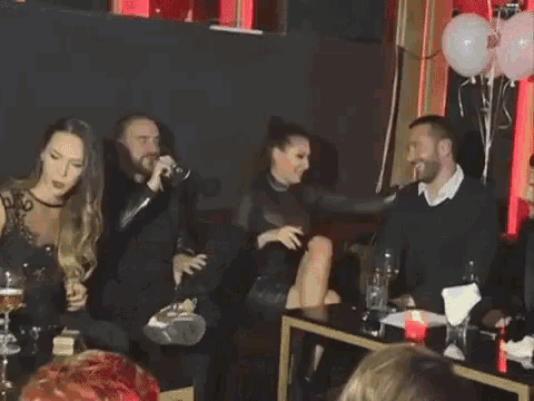 a group of people sitting on a couch kissing
