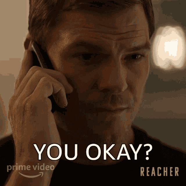 a man talking on a phone with the words " you okay " written below him