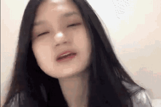 a close up of a woman 's face with her eyes closed and her mouth open .