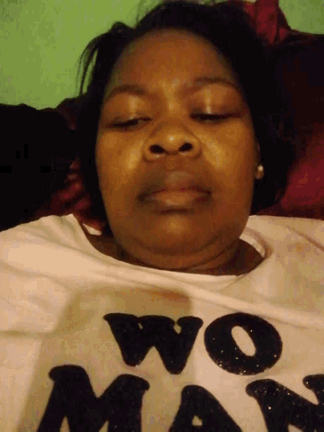 a woman with her eyes closed is wearing a white shirt with the word mom on it
