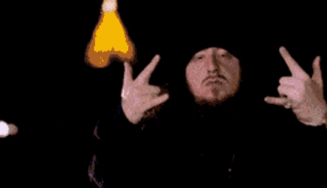 a man with a beard is covering his face with his hand in a blurry photo .