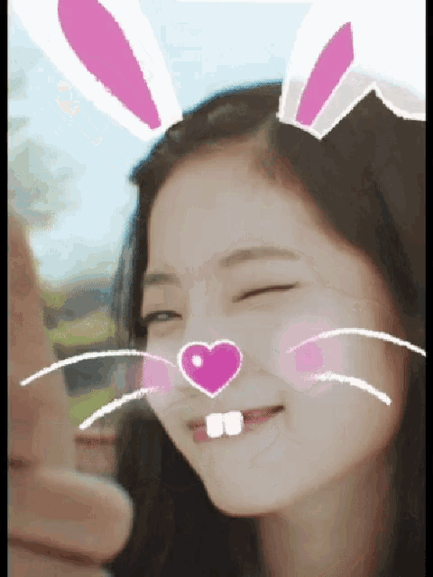 a girl with bunny ears on her head and a heart on her face