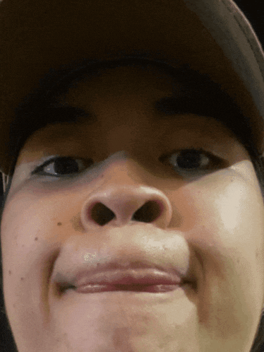 a close up of a person 's face wearing a baseball cap