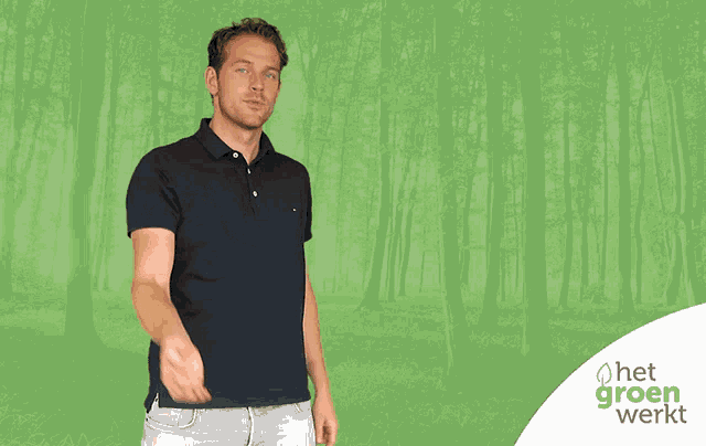 a man in a blue shirt stands in front of a green background with het groen werkt written on it