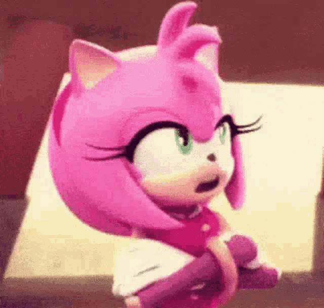 amy rose from sonic the hedgehog is sitting on a couch with her eyes closed .
